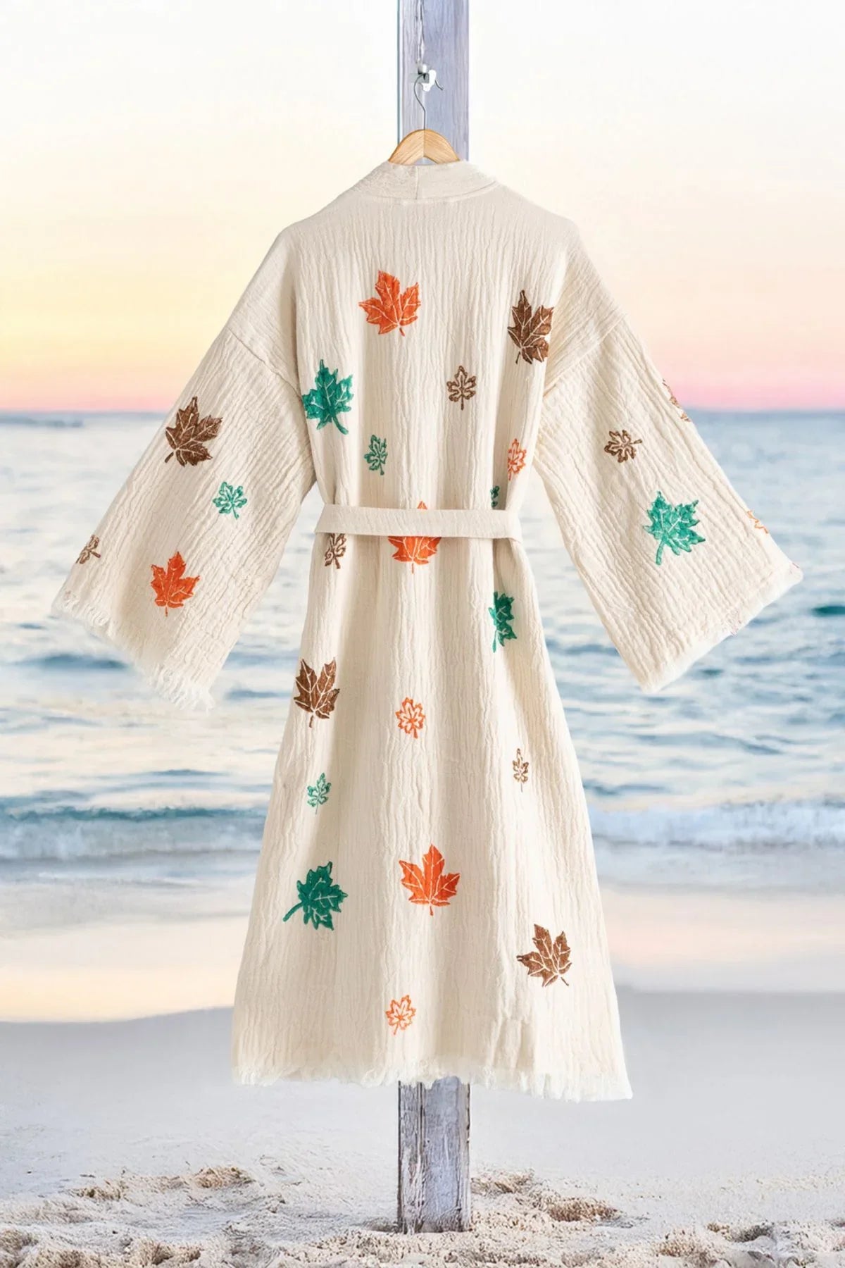 Beige Kimono mit bunten Herbstlaub-Print, Strandhintergrund