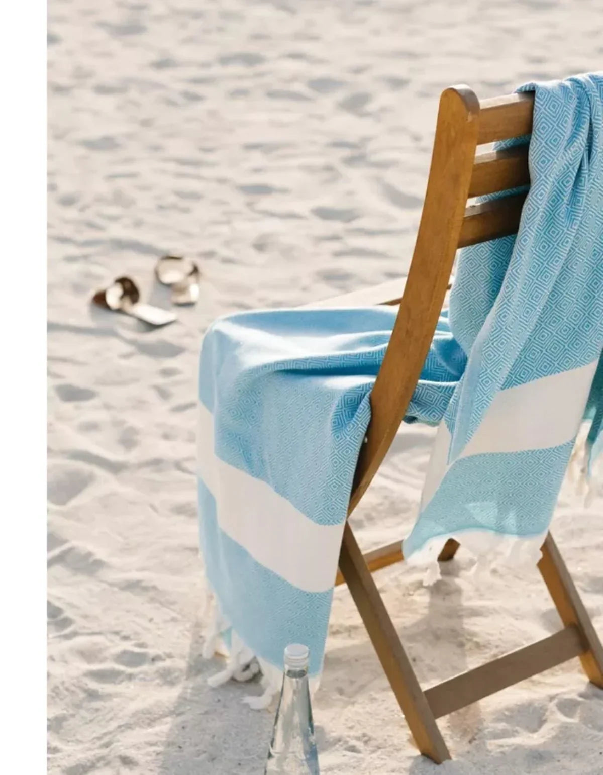 Blau-weißer waschbarer Strandtuch mit geometrischem Muster auf Holzstuhl am Sandstrand