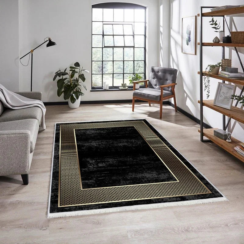 Modern living room with a black and gold geometric area rug on light wood flooring