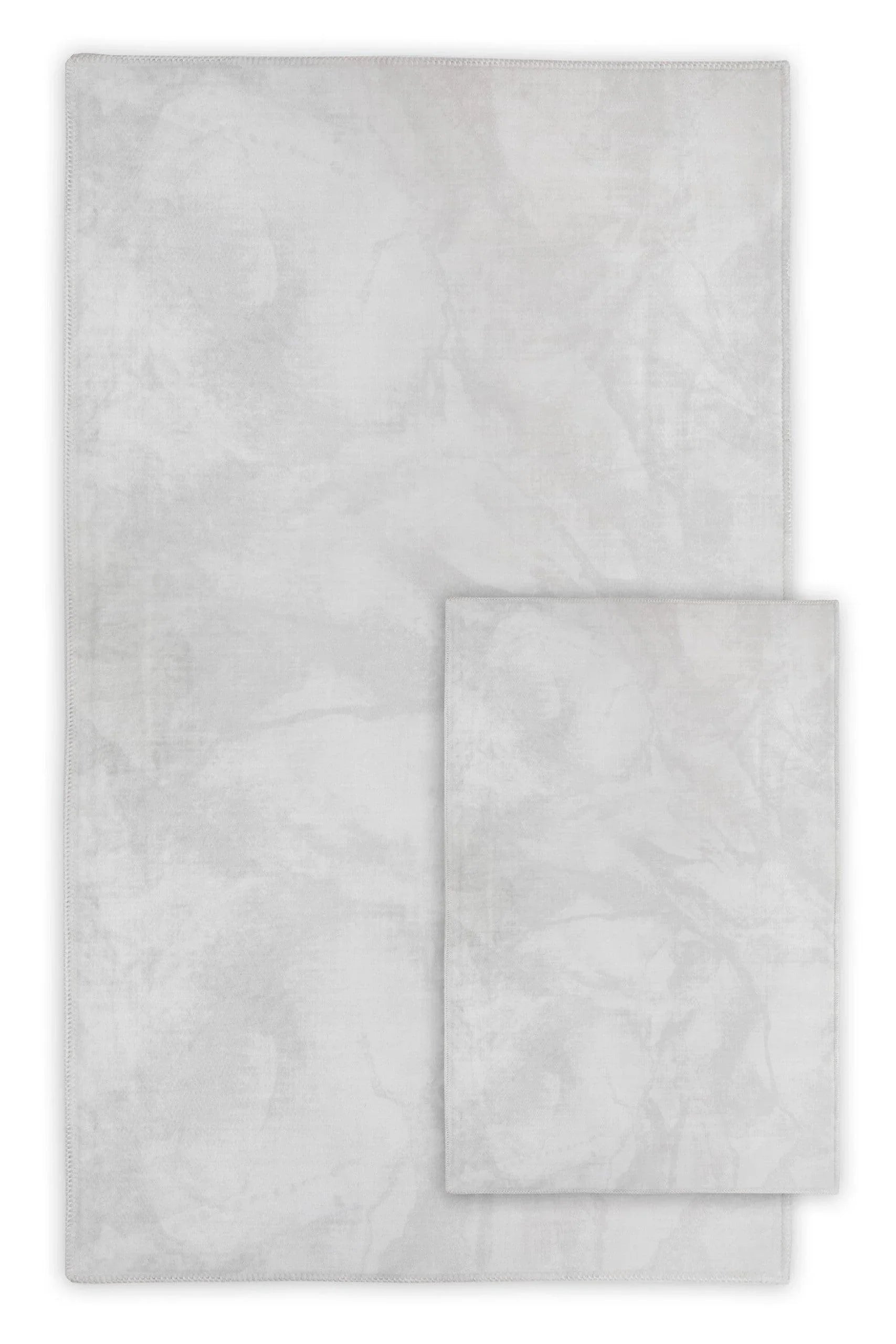 light grey washable area rugs with subtle marbled pattern, shown in two sizes